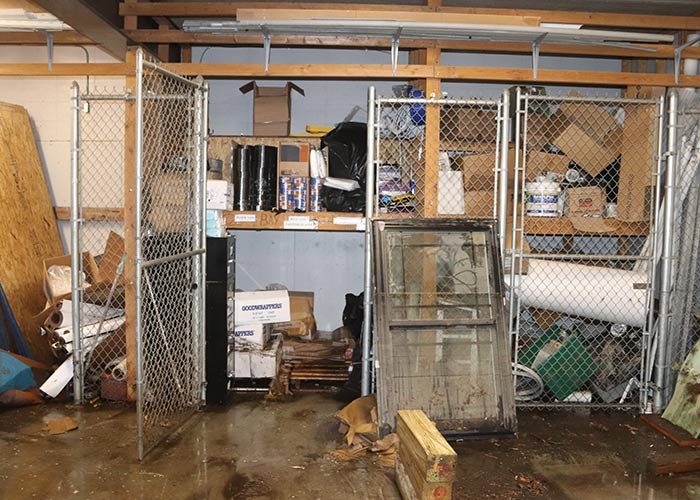 Storage area with water damage showing standing water, wet materials, and metal shelving.
